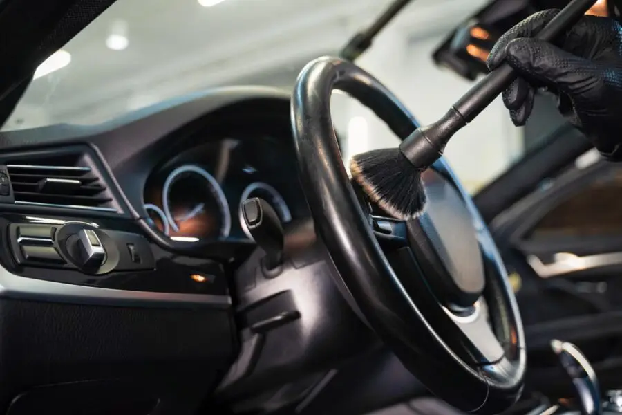 A steering wheel and dashboard being cleaned