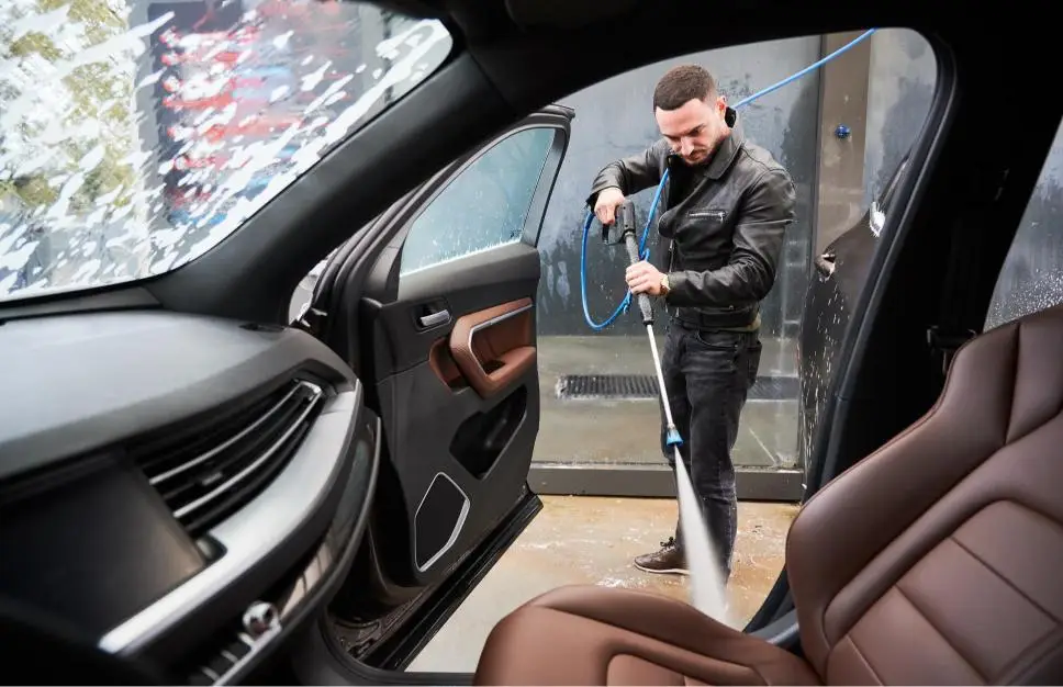 A technician washing a car by hand