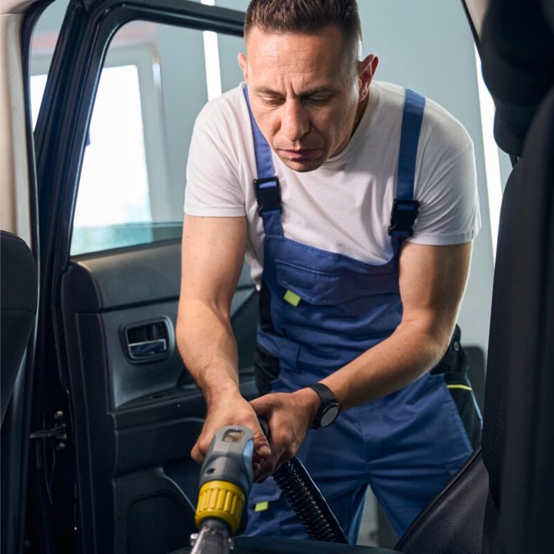 man cleans the car interior with a vacuum cleaner 2024 10 20 00 27 24 utc